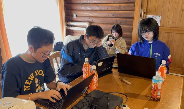 ログハウスでプレゼン資料を作成する参加者たち